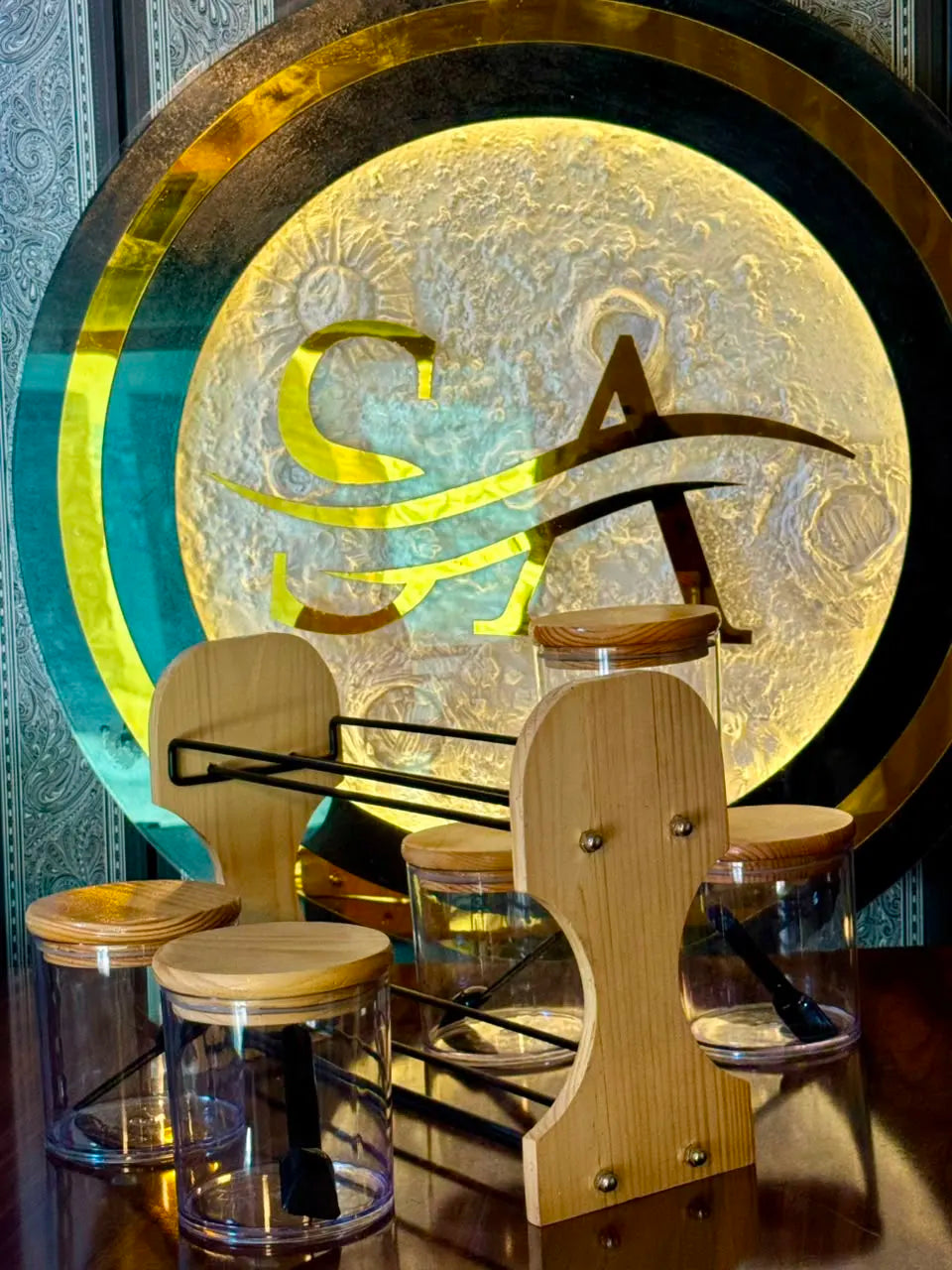 Close-up of transparent spice jars with wooden lids and serving spoons